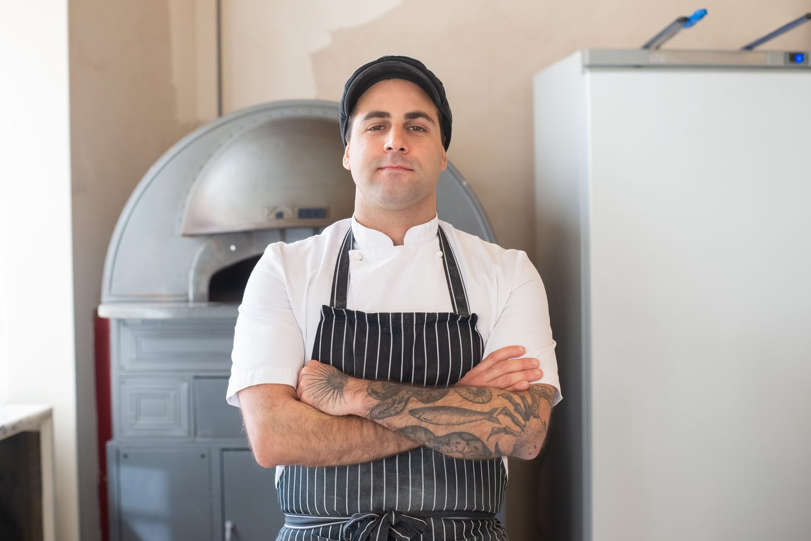 Hospitality operator standing near a food preparation oven